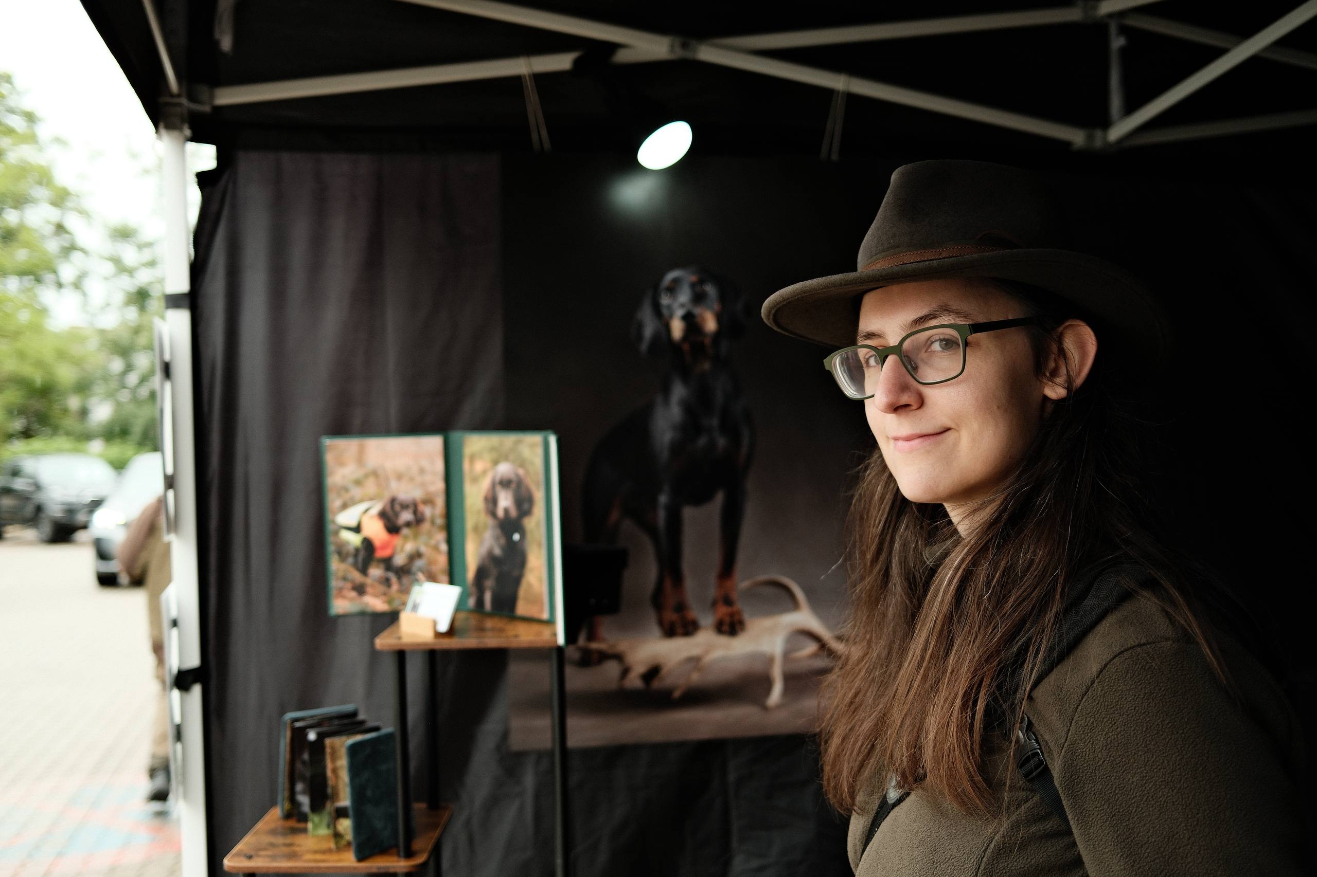 Fotografin in ihrem Stand, im Hintergrund stehen Printprodukte